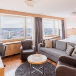 huone jossa sohvaryhmä ja kaksi erillistä sänkyä