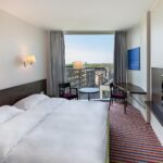 huone jossa parisänky, tuolit, kokolattiamatto, ikkuna ja tv