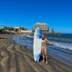 Titta Keinanen surffilaudan kanssa Teneriffan rannalla