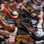 EriIaisia kenkiä monessa rivissä laatikoiden päällä.