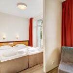 Hotellin huone jossa sänky ja vuodenojatuoli