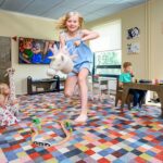 Hotellin leikkihuone, jossa lapsia leikkimässä kirjavalla matolla