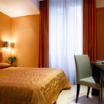 Hotellin sänky keltaisella päiväpeitolla