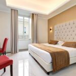 Hotellihuoneen sänky ruskealla päiväpeitteellä