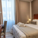 Hotellihuone, jossa parivuode ja puinen kirjoituspöytä