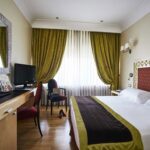 Hotellihuone jossa vihreät verhot