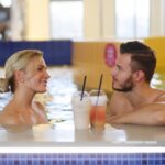 mies ja nainen nauttimassa virvokkeita uima-altaassa