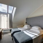 hotellihuone erillisillä vuoteilla ja kattoikkunalla