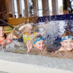 lapset leikkivät vedellä allasosastolla