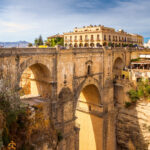 Korkea kivisilta kaarineen rotkon yllä, toisella puolella rakennuksia