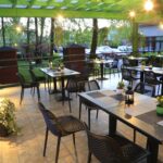 Katettu terassi jossa mustat pöydät ja tuolit