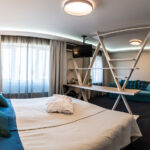 Sänky jonka edessä hyllykkö