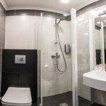 Kylpyhuone jossa suihkukoppu, wc pönttö ja lavuaari