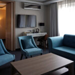 Ruskea sohvapöytä turkoosien tuolien ympyröimänä