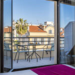Näkymä hotellihuoneen parvekkeelle, jossa kaksi tuolia ja pöytä