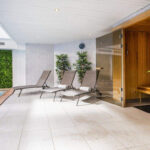 Harmaat aurinkotuolit uima-altaan edustalla