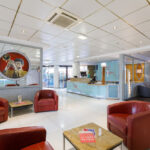 Vastaanotto tiski jonka edustalla punaisia nahkaisia nojatuoleja