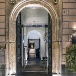 Vanhan talon oviaukko, josta näkyy hotellin käytävälle jossa seinällä iso kello ja taulu