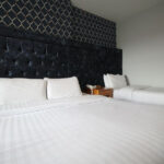 Hotellihuone, jossa yksi parivuode ja yksi yhden hengen vuode