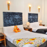 Hotellihuone, jossa Nalle Puh ja Tikru pehmolelut sängyn päällä