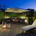 Terassi iltavalaistuksella, jossa sohvaryhmä, aurinkovarjo ja aurinkotuoli