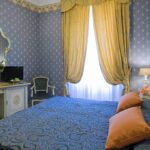 Hotellihuone, jossa romanttinen sininen sisustus keltaisilla verhoilla