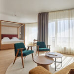 Sviitti, jossa parivuode ja istuinryhmä kahdella vihreällä nojatuolilla ja keltaisella sohvalla